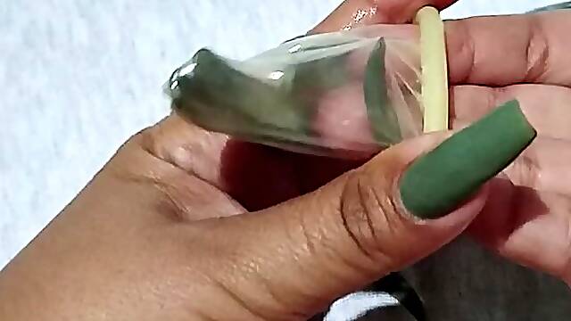 Powerful long fingernail destroying a condom.